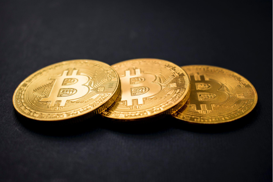 Três moedas bitcoin em um fundo preto